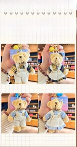 Detail of plush bear keychains in blue and brown checkered outfits with bells