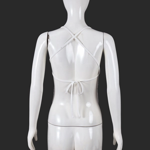 Detail of white halter neck top featuring a backless cross-strap design with a waist tie knot