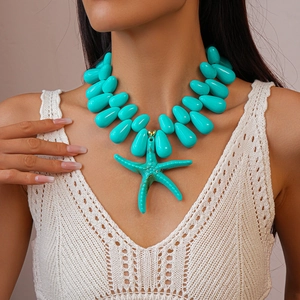 Detail of turquoise acrylic bead necklace with large starfish pendant on a model