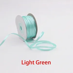 Close-up of 3mm light green double-sided satin ribbon roll for DIY crafts and gift wrapping