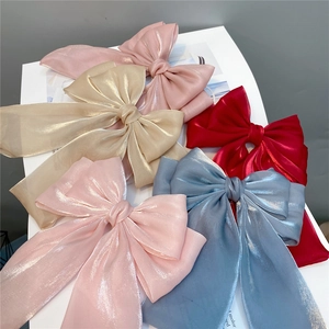 Three-layer mermaid bow hair clips in pink, gold, red, and blue iridescent satin