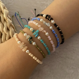 Detailed close-up of Bohemian layered beaded bracelets with natural stones and pearls