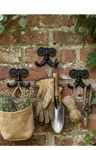 Detalle de ganchos de pared vintage de hierro fundido con forma de bigote en ladrillo