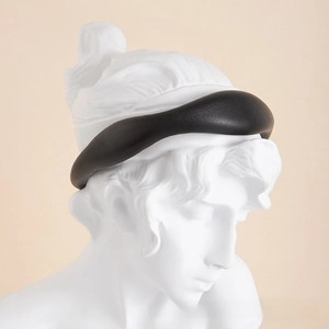 Detail view of the black faux leather padded headband on a white plaster bust display