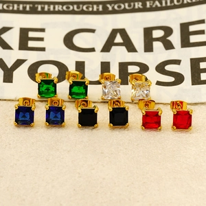 Macro shot of colorful square-cut gemstones in gold-plated four-prong earring settings