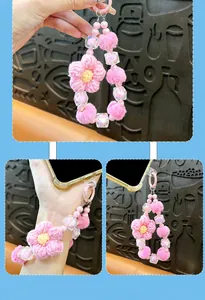 Dettaglio del cinturino per telefono rosa con fiore in lana e perline di peluche