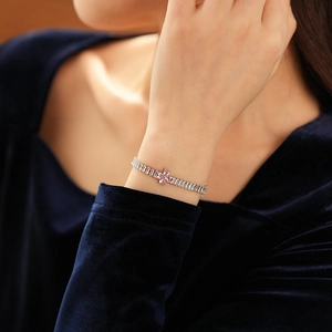 Detail of luxury zircon four-leaf clover bracelet with pink stone on model wrist
