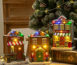 Detailed view of illuminated Christmas village resin houses with LED lights and snow effects