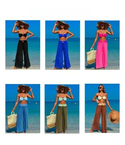 Detail view of high-waisted wide-leg beach pants with stylish metal buckle accents