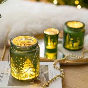 Christmas glass candle holder with green finish and LED lights on a tray display