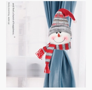 Detailed view of a plush snowman curtain tieback with a red knitted hat and striped scarf