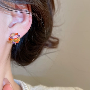 Macro shot of colorful floral crystal stud earrings with vibrant multi-faceted stones