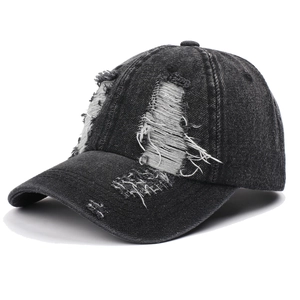 Detail of distressed ripped denim baseball cap showing white frayed fibers and dark grey fabric