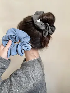 Close-up of starry fabric hair scrunchies in blue and grey with handmade label detail
