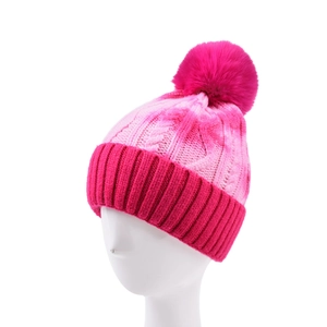 Detail of pink tie-dye cable knit winter hat featuring a large soft pom-pom on top
