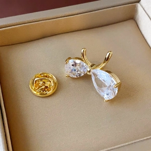 Broche nœud élégante en plaqué or avec zircons cubiques sur un support en soie