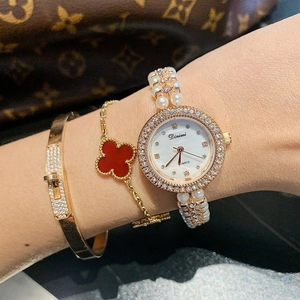Close-up of golden shell dial watch with pearl bracelet and rhinestones on wrist