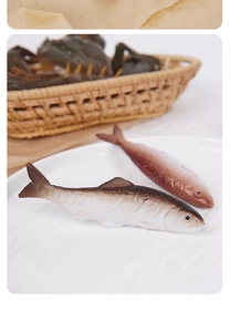 Close-up of realistic faux fish models on a ceramic plate for creative home decor