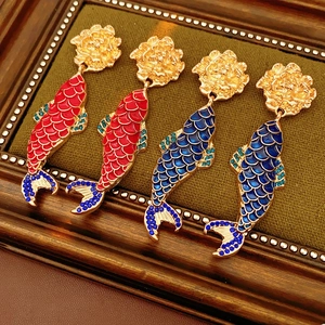 Detailed macro view of vintage koi fish earrings with colorful enamel and crystal accents