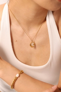 Gros plan du collier vintage plaqué or 18k avec pendentif nacre blanche et bracelet