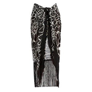 Detail of black and white plant print sarong wrap skirt with long black fringe tassels