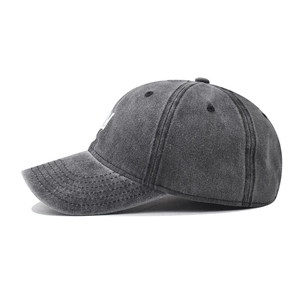 Side view of washed cotton baseball cap with white 'M' embroidery and distressed texture
