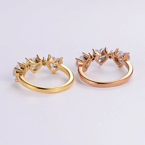 Close-up of gold and rose gold heart-shaped zircon rings in a flat lay display