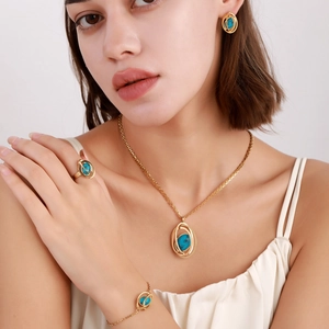 Close-up of golden jewelry set with turquoise stones worn by a model