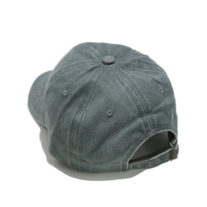 Detail of washed cotton baseball cap featuring vintage finish and adjustable metal buckle