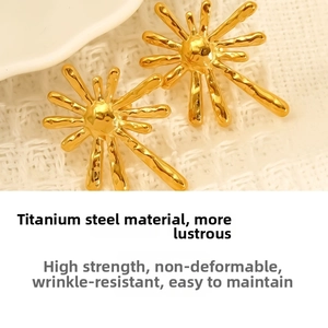 Macro detail of gold titanium steel sunburst earrings with hammered texture finish