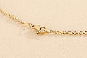 Macro shot of gold daisy jewelry set lobster clasp and polished O-chain link details
