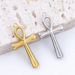 Polished stainless steel Ankh cross pendants in gold and silver on natural stone