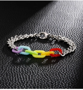 Macro shot of rainbow acrylic links and silver metal chain bracelet on black leather