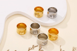 Close-up of gold and silver stainless steel rings with Tree of Life cutout patterns