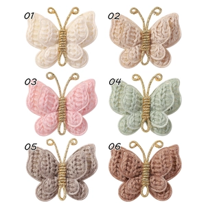 Macro detail of six knitted yarn butterfly hair clips with intricate crochet textures