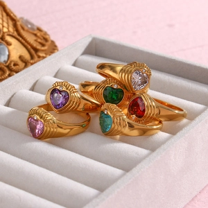 Close-up of five 18K gold plated rings with heart-shaped colorful zircon stones in a box