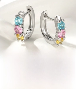Macro detail of 8mm silver hoop earring with blue pink and yellow cubic zirconia stones