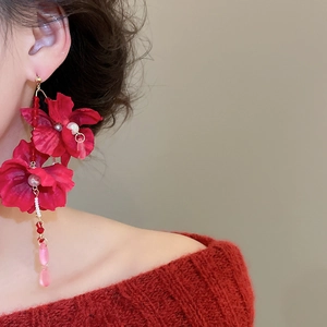 Detail of red fabric flower earrings with crystal tassels and pearls for beach vacation
