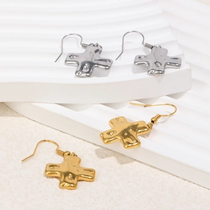 Détail de boucles d'oreilles croix en or 18K et argent avec texture métal liquide