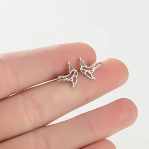 Minimalist silver swallow stud earrings featuring a hollowed-out bird flight silhouette