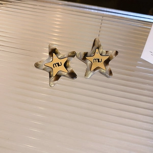 Close-up of double-layer star stud earrings with leopard print resin and gold-plated star