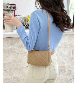Close-up of khaki quilted underarm bag with elegant lattice stitching and slim strap