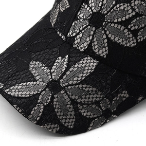 Detailed close-up of floral lace embroidery and mesh texture on the black baseball cap