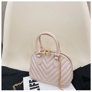 Detail of pink jelly shell bag with V-quilted pattern and gold chain strap