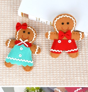 Detail of Christmas gingerbread doll set made of soft felt with festive red bow tie