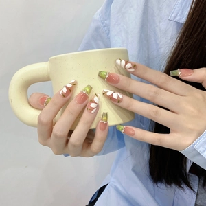 Handmade green gradient press-on nails with white floral patterns and small rhinestones