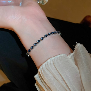 Detail of adjustable silver bracelet featuring blue teardrop zircon stones on wrist