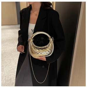 Close-up of golden crescent moon handbag with quilted texture and metallic round handle