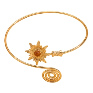 Detail of vintage gold sun arm cuff with turquoise stone and spiral boho design