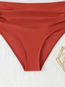 Detailed macro view of red high-waisted bikini bottoms featuring elegant side ruching